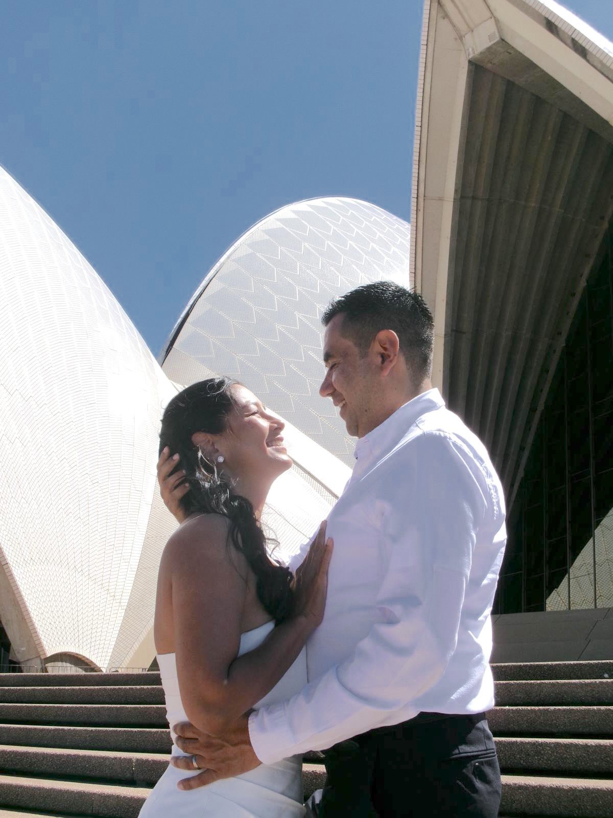 Pilar y Juan abrazados y sonriendo frente a la Ópera de Sídney